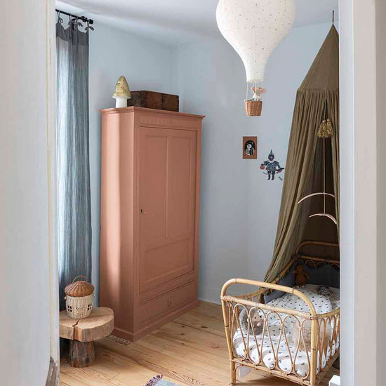 Ambiance d'une chambre d'enfant aux murs bleu, avec armoire rose, peinture Meuble Signé Mat à base de Caséine teinte Ocre Rose Libéron