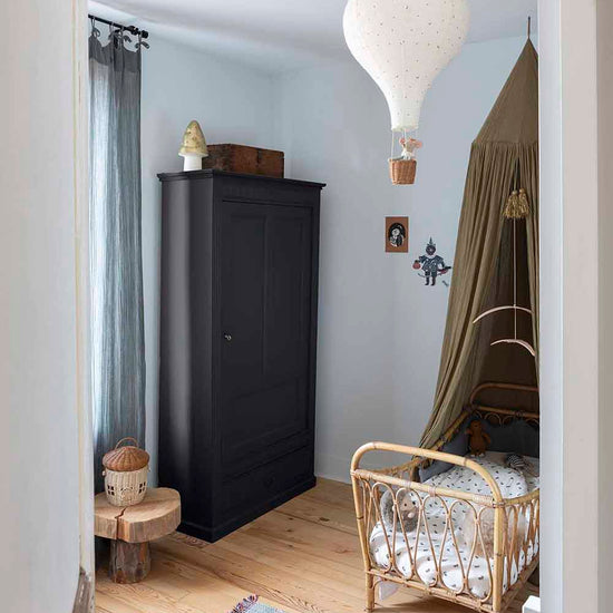 Ambiance d'une chambre d'enfant aux murs bleu, avec armoire noire, peinture Meuble Signé Mat à base de Caséine teinte Queue de Pie Libéron