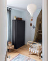 Ambiance d'une chambre d'enfant aux murs bleu, avec armoire noire, peinture Meuble Signé Mat à base de Caséine teinte Queue de Pie Libéron