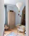 Ambiance d'une chambre d'enfant aux murs bleu, avec armoire rose, peinture Meuble Signé Mat à base de Caséine teinte Rose Poudré Libéron
