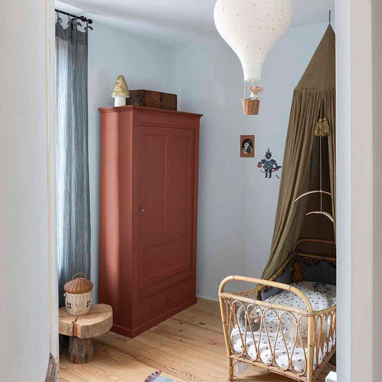 Ambiance d'une chambre d'enfant aux murs bleu, avec armoire rouge, peinture Meuble Signé Mat à base de Caséine teinte Rouge Pouzzolane Libéron