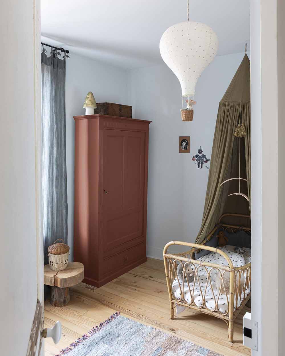 Ambiance d'une chambre d'enfant aux murs bleu, avec armoire rouge, peinture Meuble Signé Mat à base de Caséine teinte Rouge Pouzzolane Libéron