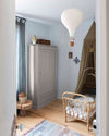 Ambiance d'une chambre d'enfant aux murs bleu, avec armoire beige, peinture Meuble Signé Mat à base de Caséine teinte Soie Grège Libéron