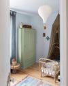 Ambiance d'une chambre d'enfant aux murs bleu, avec armoire verte, peinture Meuble Signé Mat à base de Caséine teinte Vert à Soie Libéron