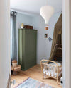 Ambiance d'une chambre d'enfant aux murs bleu, avec armoire verte, peinture Meuble Signé Mat à base de Caséine teinte Vert Bivouac Libéron