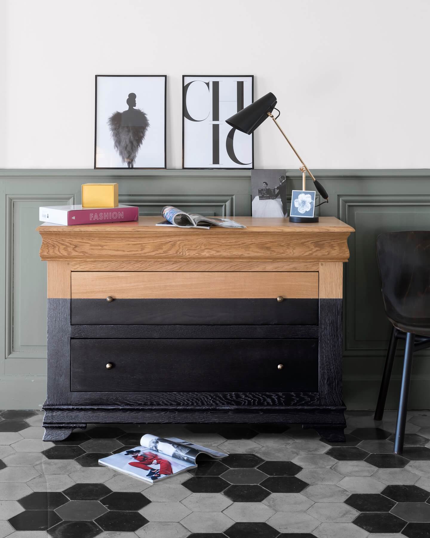 Commode en bois et noir brillant Libéron dans une ambiance bureau, avec mur vert grisé, lampe et affiches.