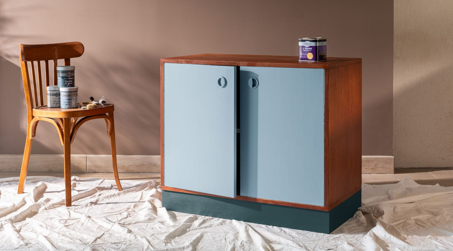 Meuble en bois rénové avec portes bleu clair Libéron et base bleu foncé, pots Meuble signé en décor.