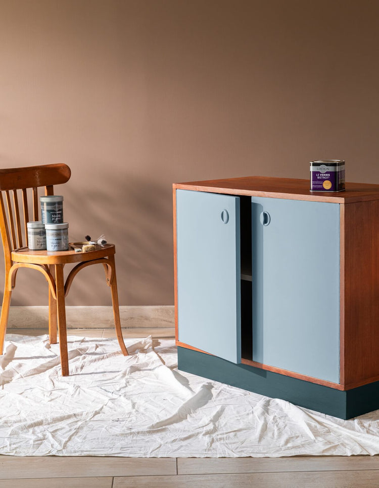 Meuble en bois rénové avec portes bleu clair Libéron et base bleu foncé, pots Meuble signé en décor.