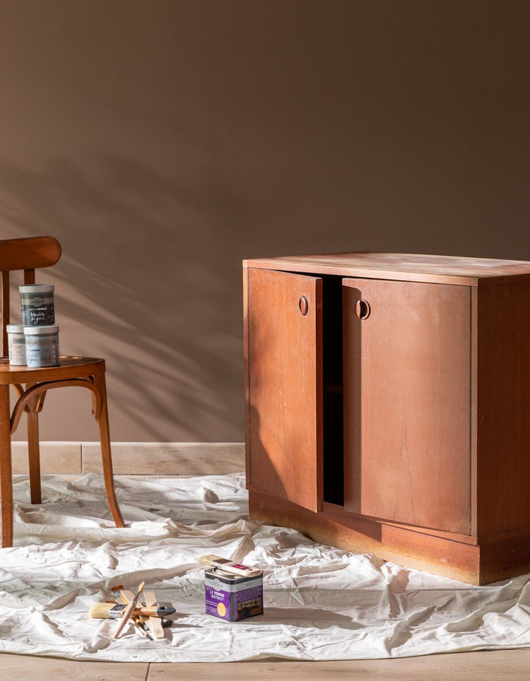 Meuble en bois avant peinture velours Libéron, avec pot Le Vernis Bistrot, pinceaux et toile de protection.
