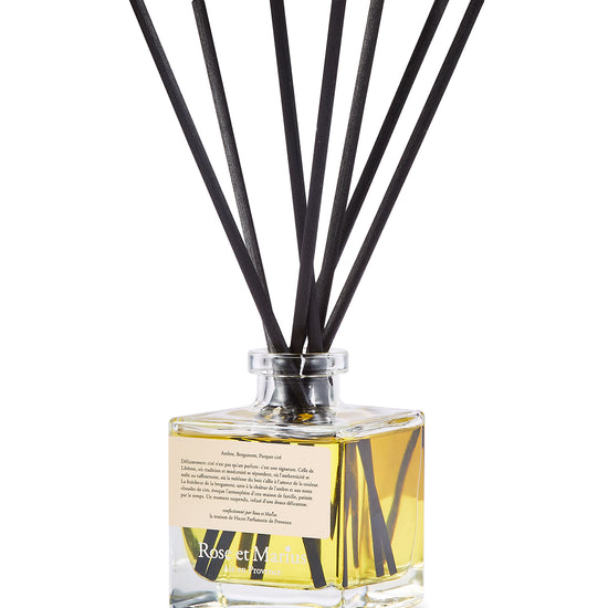 Diffuseur de parfum d’intérieur Libéron, flacon en verre avec tiges noires, signé Rose et Marius.