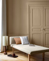 Salon aux murs beige bottier Libéron, avec méridienne écrue, portes assorties, coussins terracotta et parquet clair.