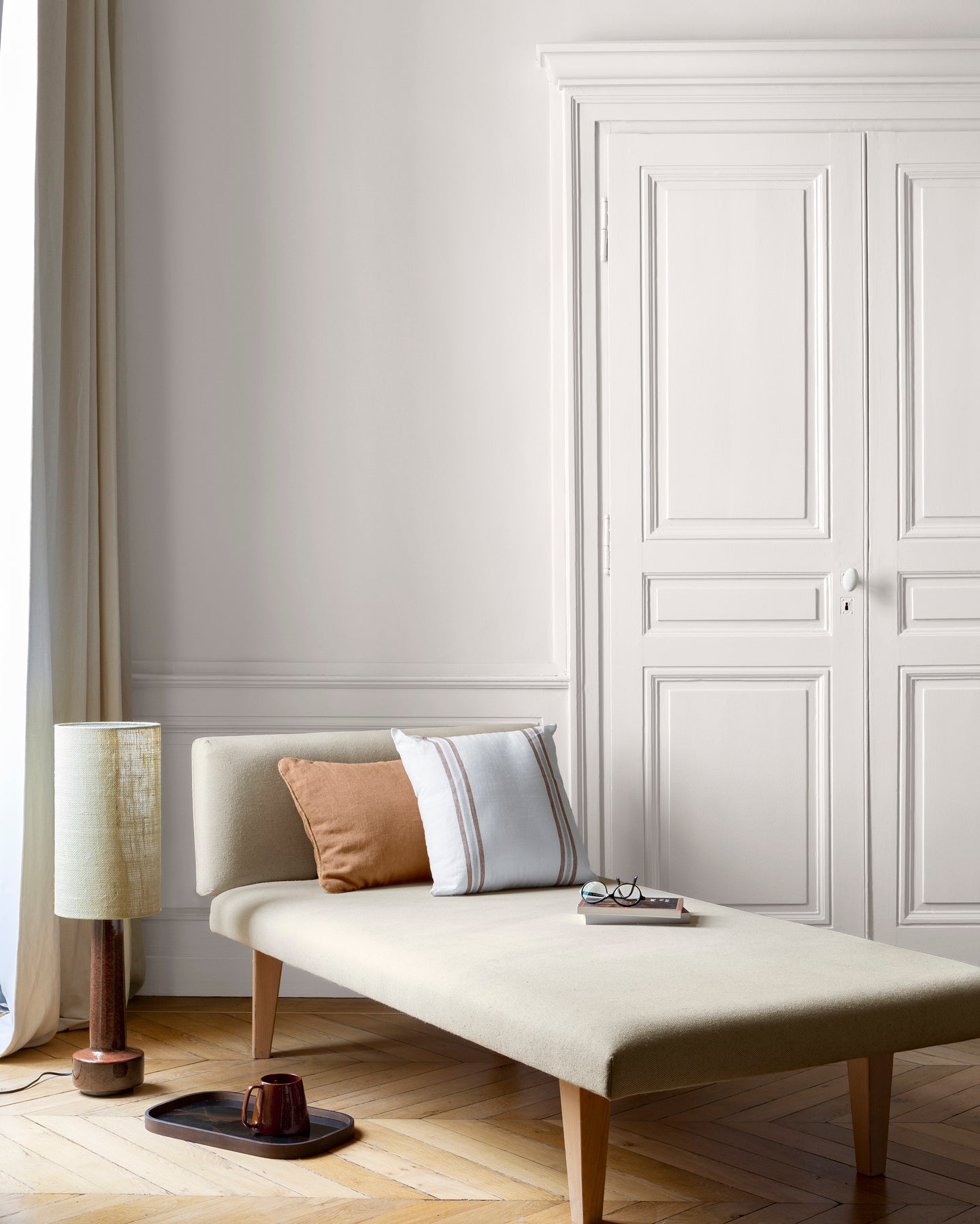 Salon lumineux avec porte et murs blancs, peinture 163 Faubourg Blanc Mousseline Libéron, avec méridienne blanche