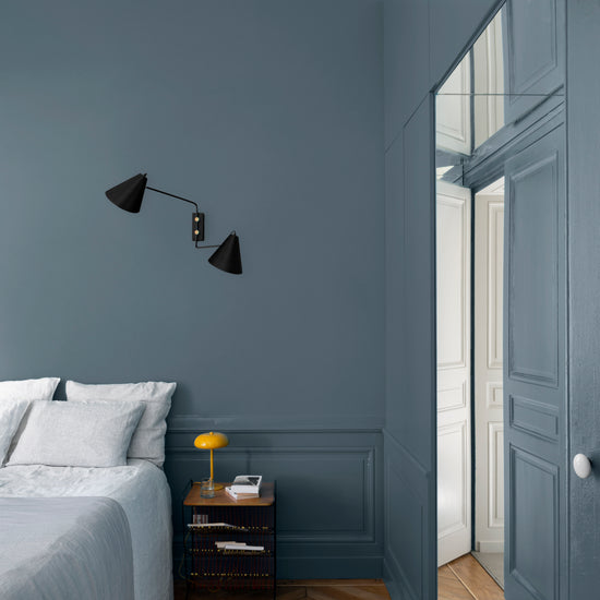 Chambre aux murs bleu couture et bleu zingueur Libéron, avec lit clair, parquet en chevrons et placard assorti.