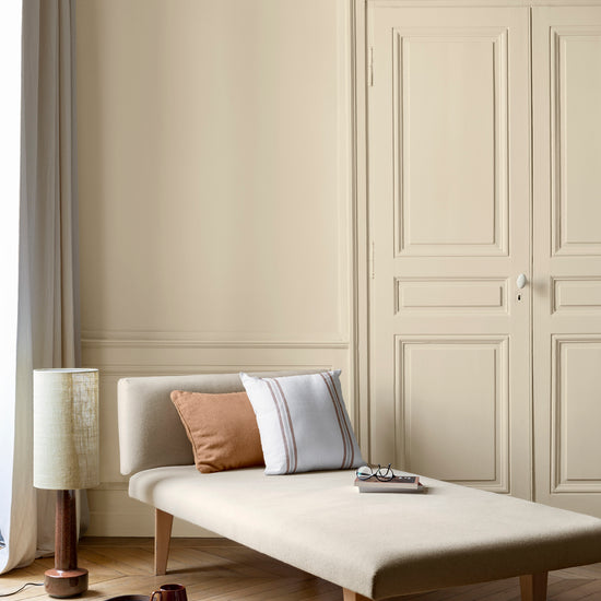 Salon aux murs Crème Saint-Honoré 163 Faubourg Libéron, avec méridienne écrue, portes assorties et parquet clair.