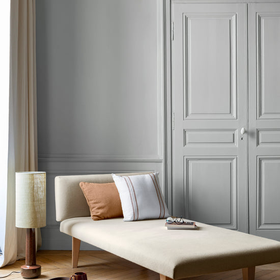 Salon aux murs Gris Fer Blanc 163 Faubourg Libéron, avec méridienne écrue, portes assorties et parquet clair.