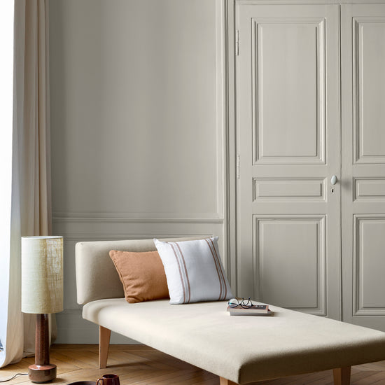 Salon aux murs Lait d'Amande 163 Faubourg Libéron, avec méridienne écrue, portes assorties et parquet clair.