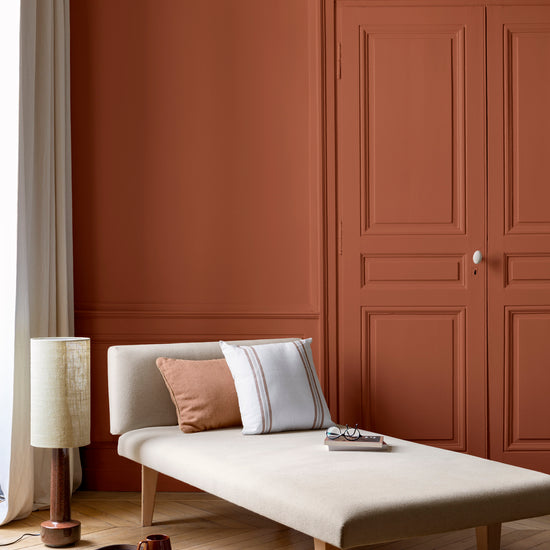 Salon lumineux avec porte et murs oranges, peinture 163 Faubourg Orange de Forge Libéron, avec méridienne blanche