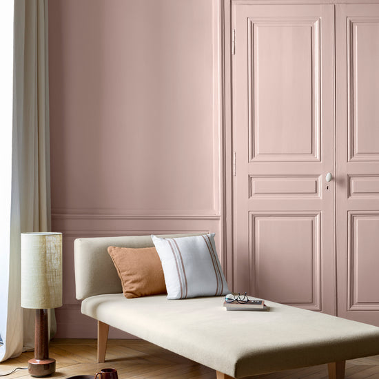 Salon lumineux avec porte et murs roses, peinture 163 Faubourg Rose Diva Libéron, avec méridienne blanche