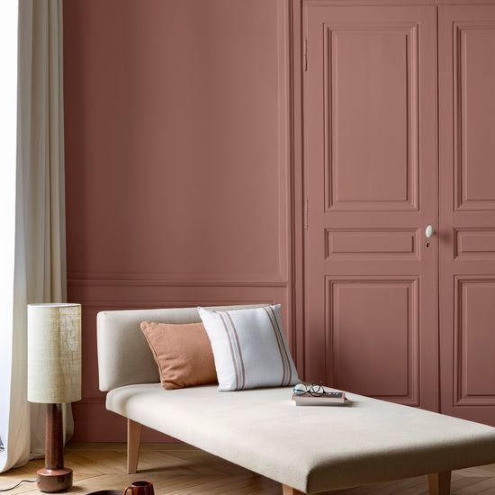 Salon lumineux avec porte et murs roses, peinture 163 Faubourg Rose Floral Libéron, avec méridienne blanche