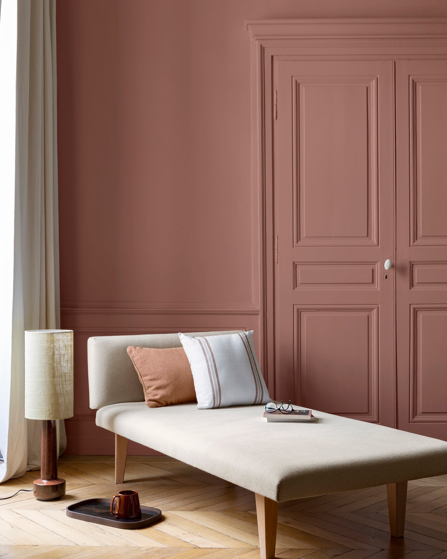 Salon lumineux avec porte et murs roses, peinture 163 Faubourg Rose Floral Libéron, avec méridienne blanche