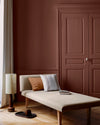 Salon lumineux avec porte et murs rouges, peinture 163 Faubourg Rouge de Terre Libéron, avec méridienne blanche
