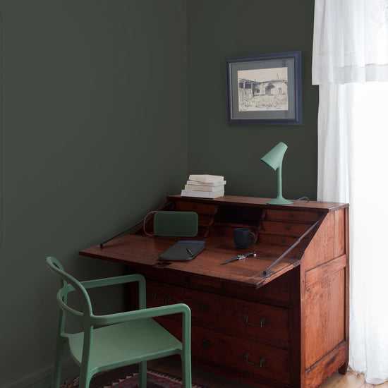 Coin bureau teint avec La Teinte Antiquaire Acajou Libéron, chaise, lampe et murs verts, et cadre accroché au mur