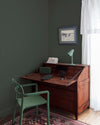 Coin bureau teint avec La Teinte Antiquaire Acajou Libéron, chaise, lampe et murs verts, et cadre accroché au mur