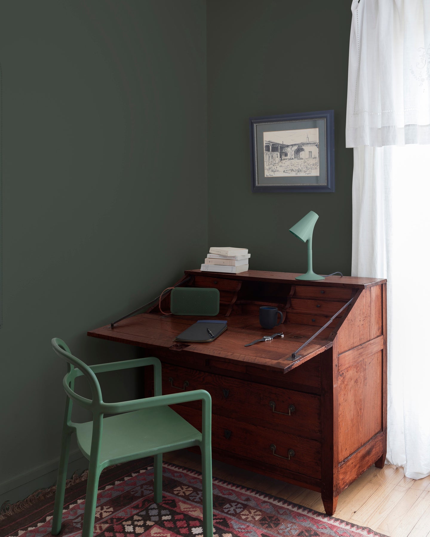 Coin bureau teint avec La Teinte Antiquaire Acajou Libéron, chaise, lampe et murs verts, et cadre accroché au mur