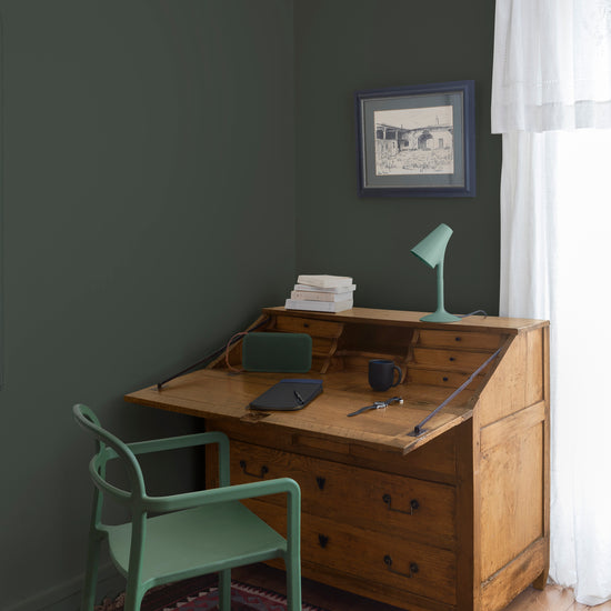 Coin bureau teint avec La Teinte Antiquaire Chêne Clair Libéron, chaise, lampe et murs verts, et cadre accroché au mur