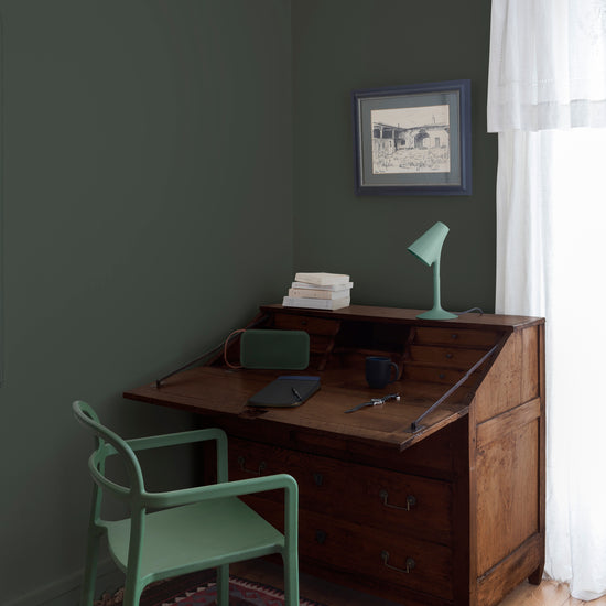 Coin bureau teint avec La Teinte Antiquaire Chêne Foncé Libéron, chaise, lampe et murs verts, et cadre accroché au mur