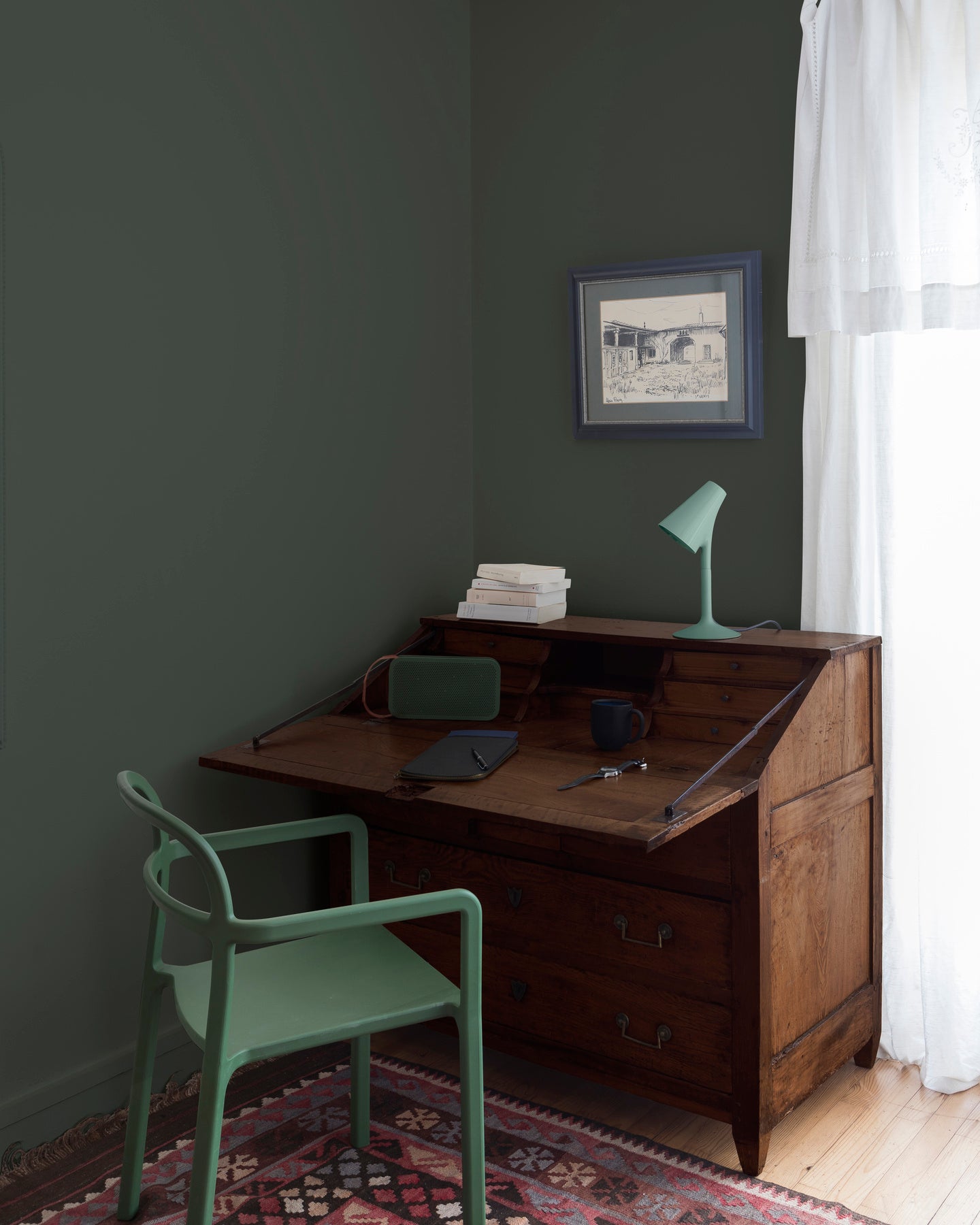 Coin bureau teint avec La Teinte Antiquaire Chêne Foncé Libéron, chaise, lampe et murs verts, et cadre accroché au mur