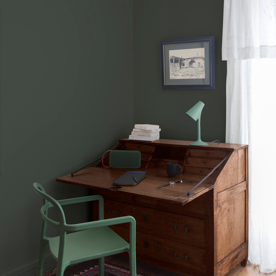 Coin bureau teint avec La Teinte Antiquaire Chêne Moyen Libéron, chaise, lampe et murs verts, et cadre accroché au mur