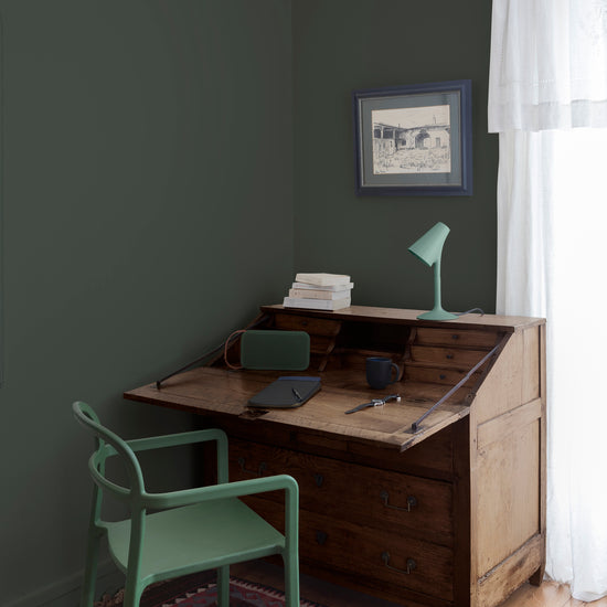 Coin bureau teint avec La Teinte Antiquaire Noyer Libéron, chaise, lampe et murs verts, et cadre accroché au mur