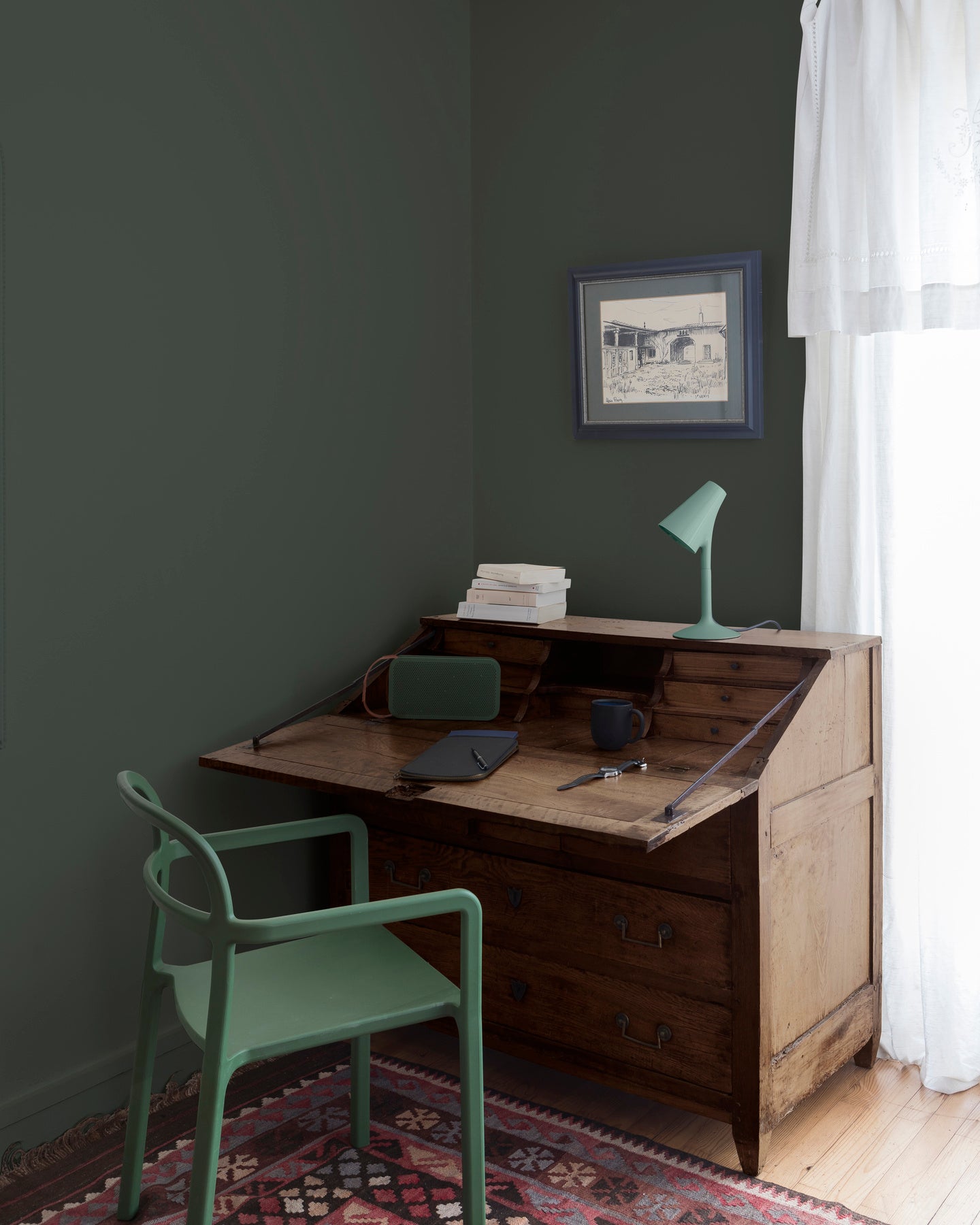 Coin bureau teint avec La Teinte Antiquaire Noyer Libéron, chaise, lampe et murs verts, et cadre accroché au mur