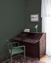 Coin bureau teint avec La Teinte Antiquaire Wengé Libéron, chaise, lampe et murs verts, et cadre accroché au mur