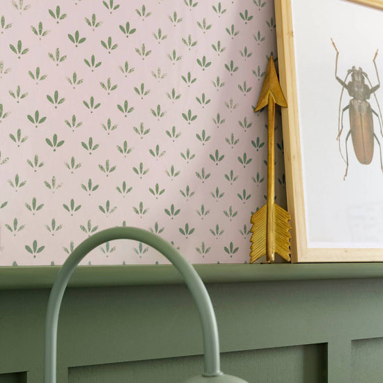 Détail de mur Florette Libéron, avec papier peint rose poudré à petit motif vert, soubassement vert sauge et cadre insecte.