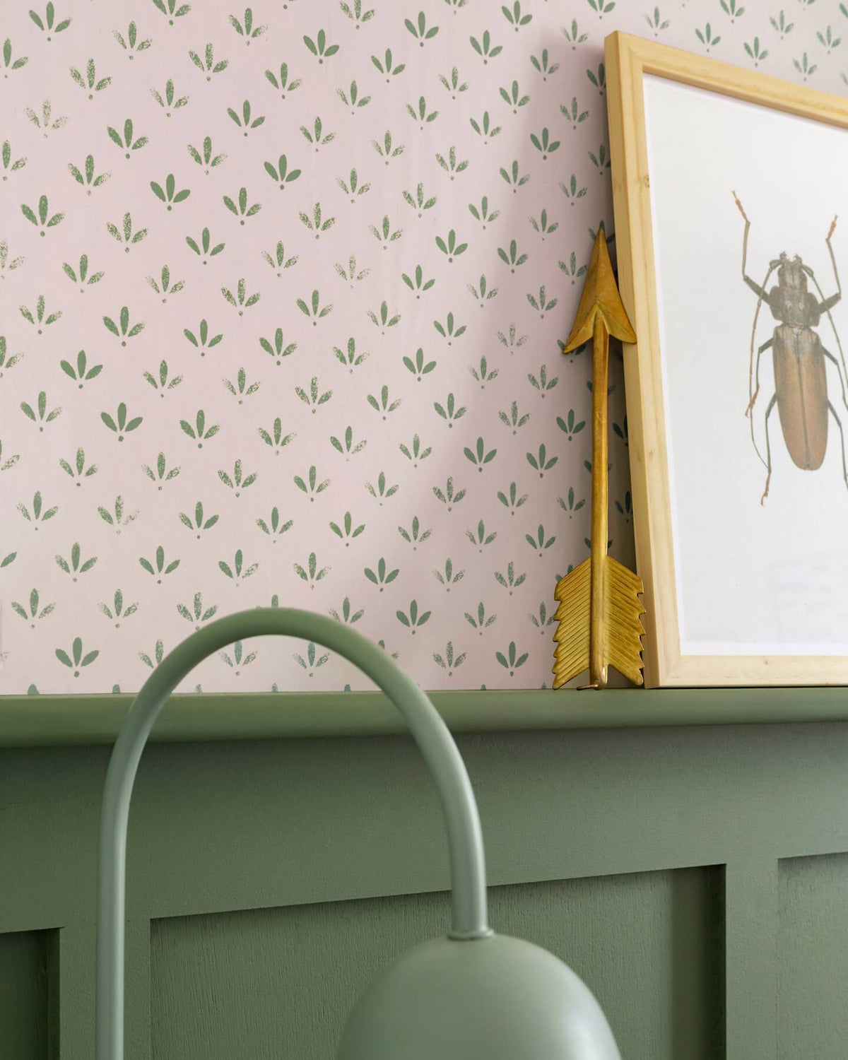 Détail de mur Florette Libéron, avec papier peint rose poudré à petit motif vert, soubassement vert sauge et cadre insecte.