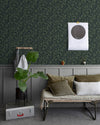 Salon au mur floral sombre, teinte Œillet Reine Libéron, avec banquette kaki, plante verte et soubassement gris.