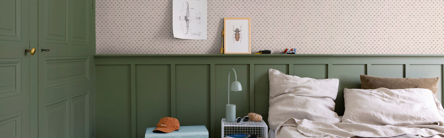 Chambre avec placard et soubassement peint en Vert Treillis Velours de Peinture Libéron, papier peint Velours de Papier Florette N°2, draps beiges, affiches et cadres.
