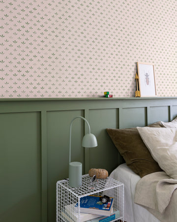 Chambre avec soubassement peint en Vert Treillis Velours de Peinture Libéron, papier peint Velours de Papier Florette N°2, draps beiges, table de nuit blanche et lampe verte.