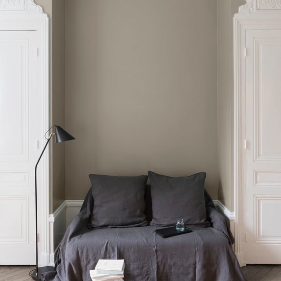 Salon aux murs beiges, peinture Velours de Peinture Beige Quai de Seine Libéron, avec portes blanches et textiles gris.