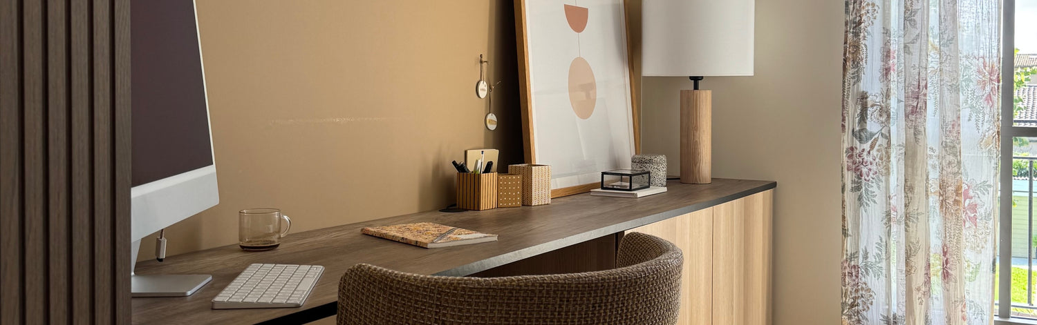 Coin bureau en bois avec murs peints en Blanc Calicot et Chêne Liège Velours de Peinture Libéron, rideau à fleurs,  lampe et pots à crayons en bois, cahier et cadre posé sur le bureau.