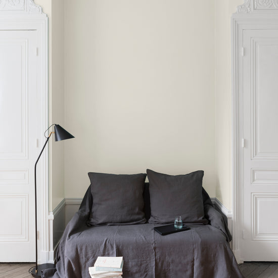 Salon aux murs blancs, peinture Velours de Peinture Blanc Calicot Libéron avec portes blanches et textiles gris.