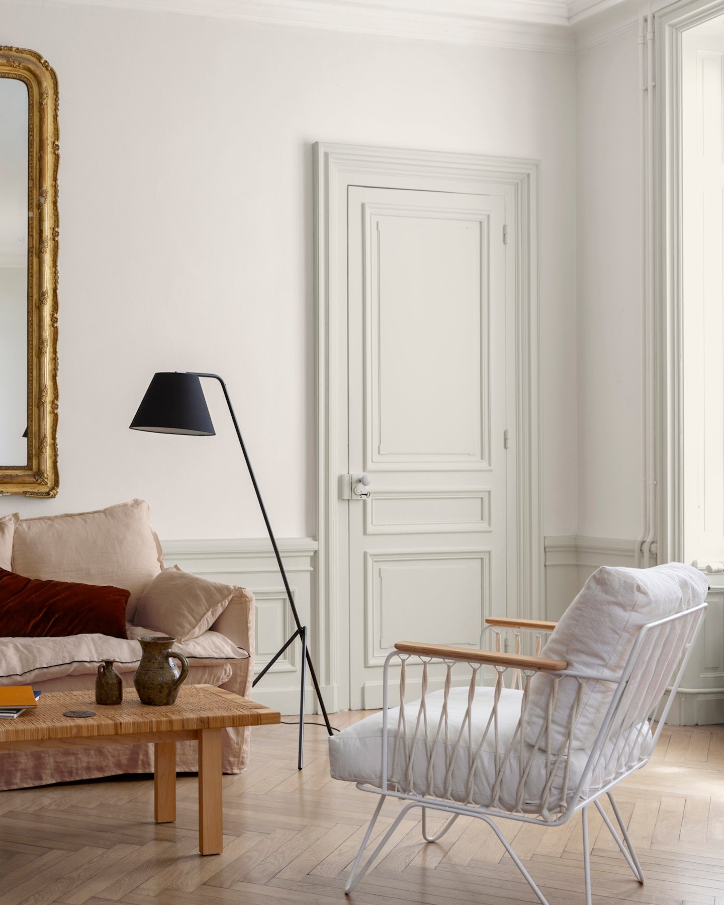 Salon aux murs blancs, peinture Velours de Peinture Blanc Camélia Libéron, avec porte blanche moulurée et canapé beige