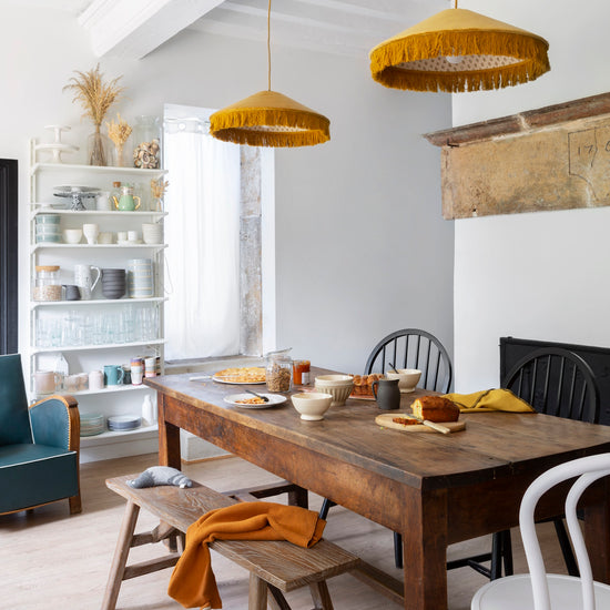 Salle à manger chaleureuse aux murs blancs, peinture Velours de Peinture Blanc Chiffon Libéron, lustres jaunes et table en bois