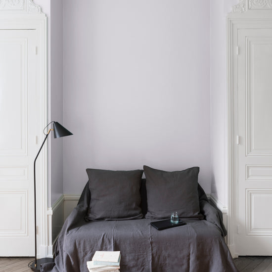 Salon aux murs blanc de Meudon Libéron, avec canapé gris, portes blanches, lampadaire noir et parquet clair.
