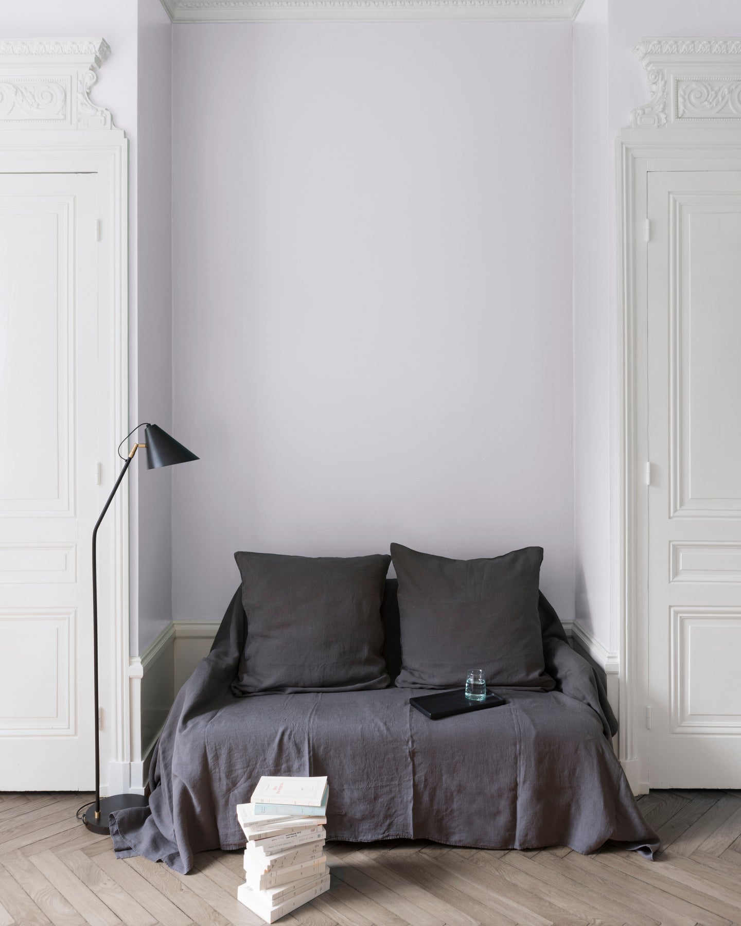 Salon aux murs blanc de Meudon Libéron, avec canapé gris, portes blanches, lampadaire noir et parquet clair.