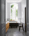 Salle de bain ensoleillée aux murs blancs, peinture Velours de Peinture Blanc Dépoli Libéron, baignoire noire et meuble en bois