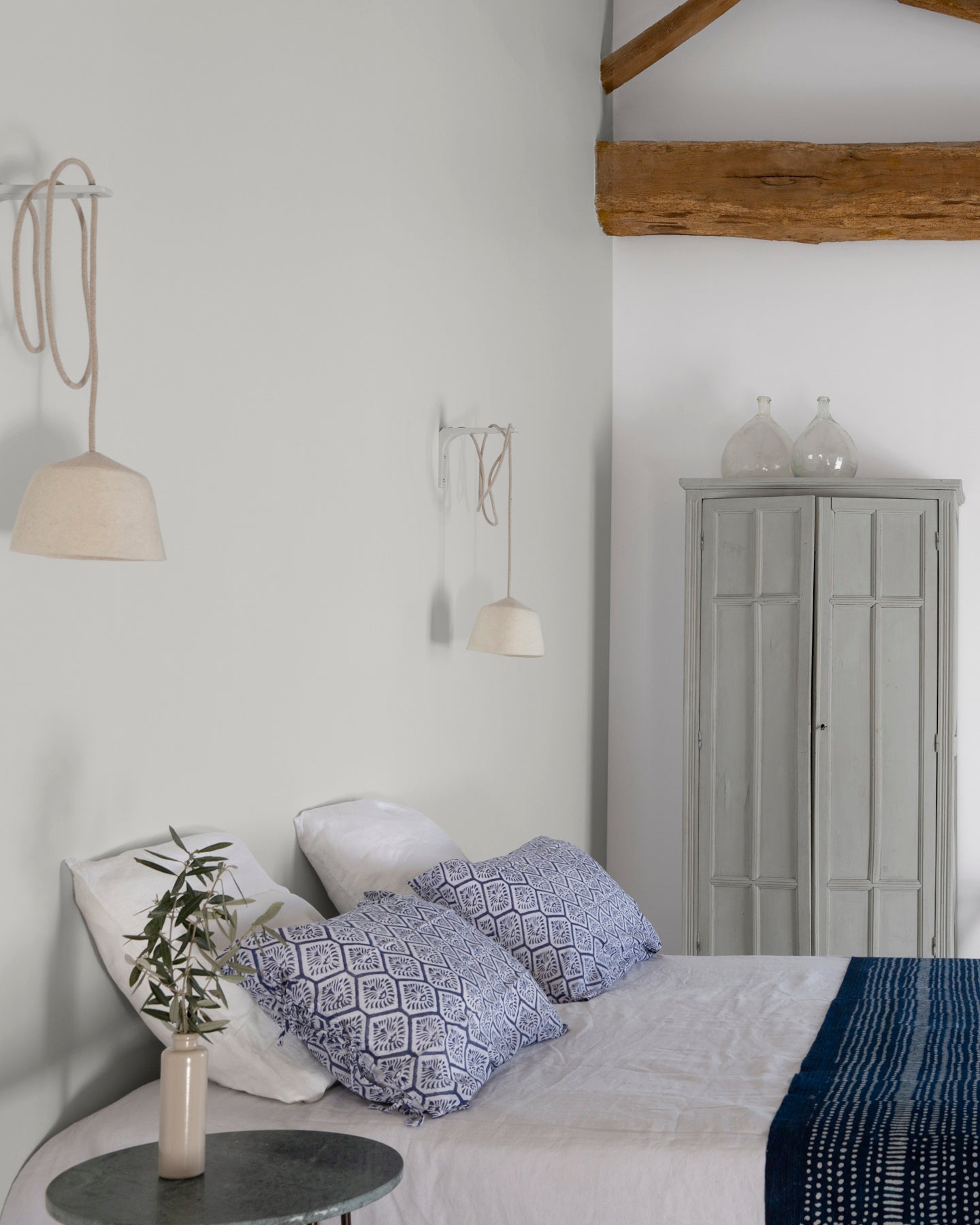 Chambre ambiance maritime aux murs blancs, Velours de Peinture Blanc Grisaille Libéron, linge de lit blanc et bleu et poutres en bois