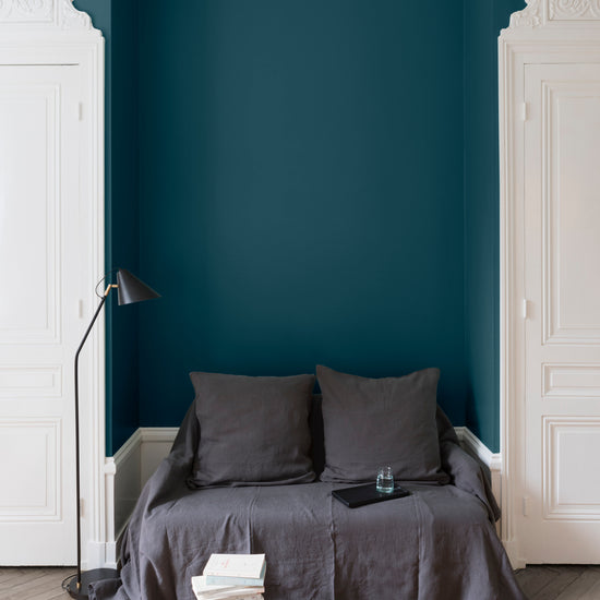 Salon aux murs bleus, peinture Velours de Peinture Bleu d'Auvergne Libéron avec portes blanches et textiles gris.